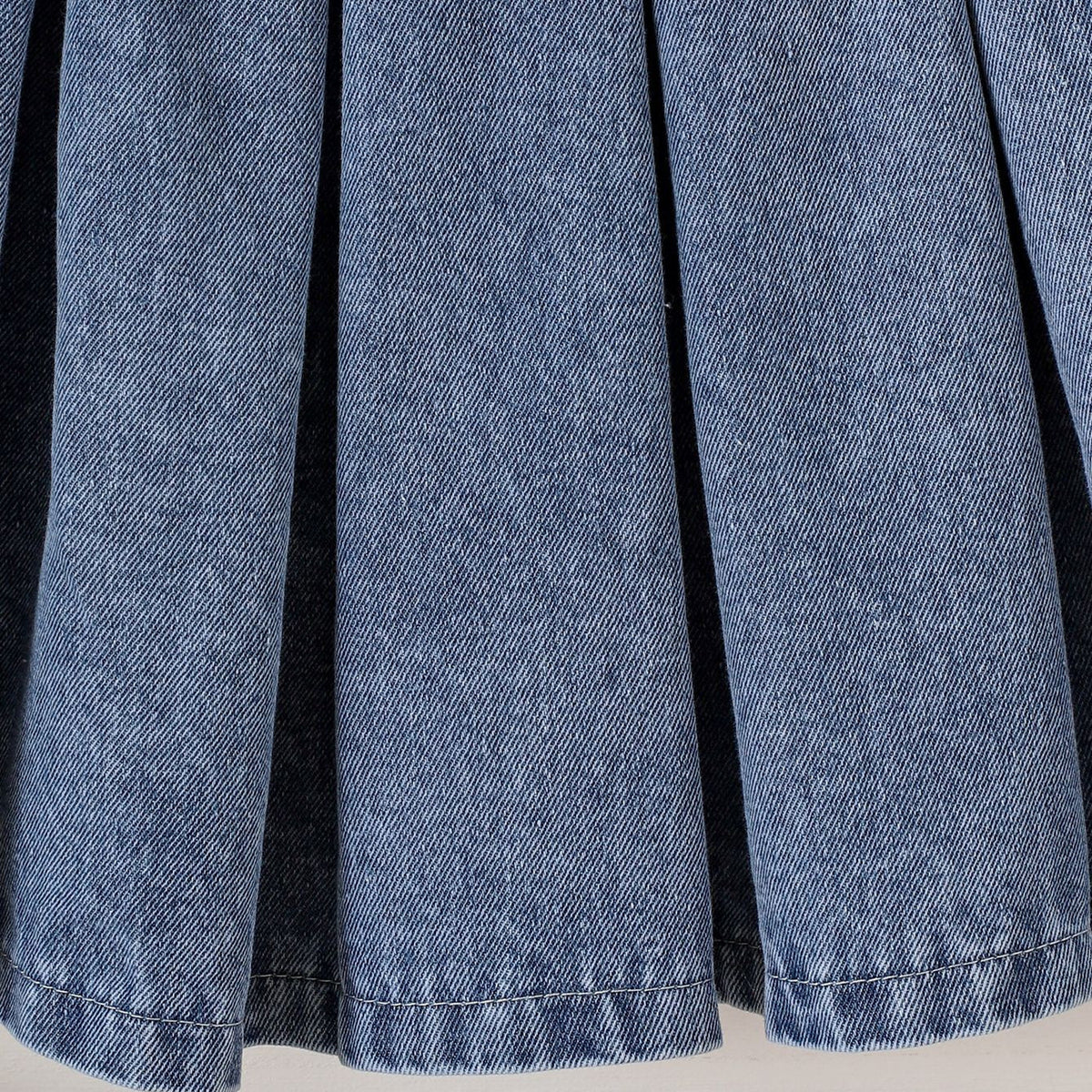 Two piece set of long sleeved sweatshirt with pleated denim skirt